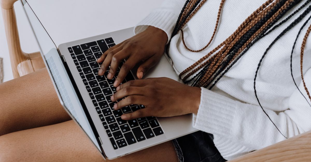 Person typing on a laptop indoors, showcasing modern technology and lifestyle.